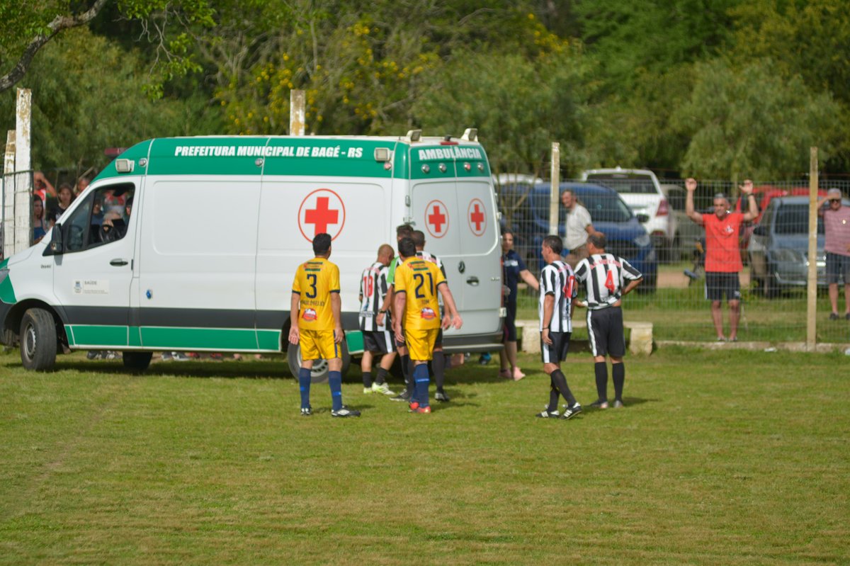 Ambulância estacionada durante partida de futebol amador no Complexo Esportivo Presidente Médici