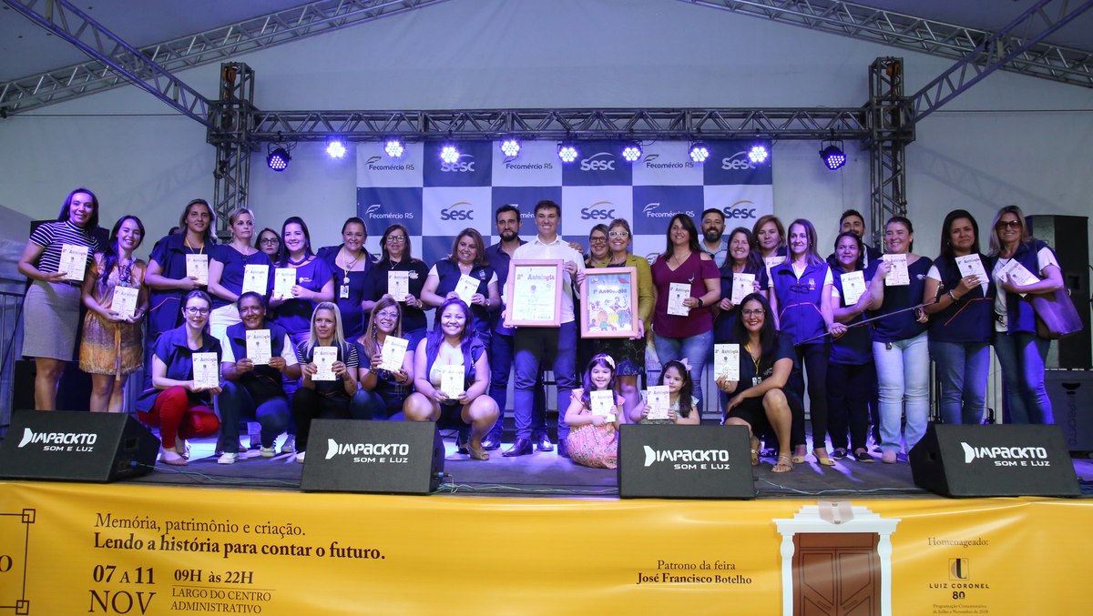 Grande grupo de alunos e equipe da Secretaria de Educação em evento de lançamento da Antologia