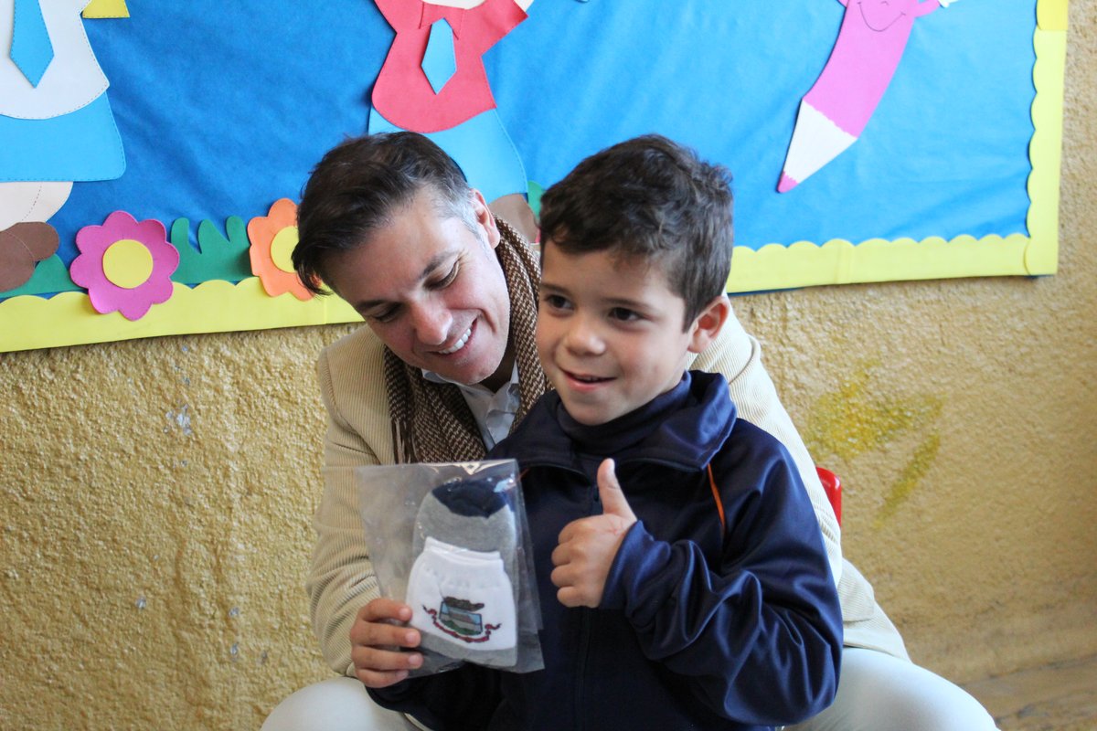 Divaldo Lara mostra as novas meias do uniforme escolar a aluno da Educação Infantil.