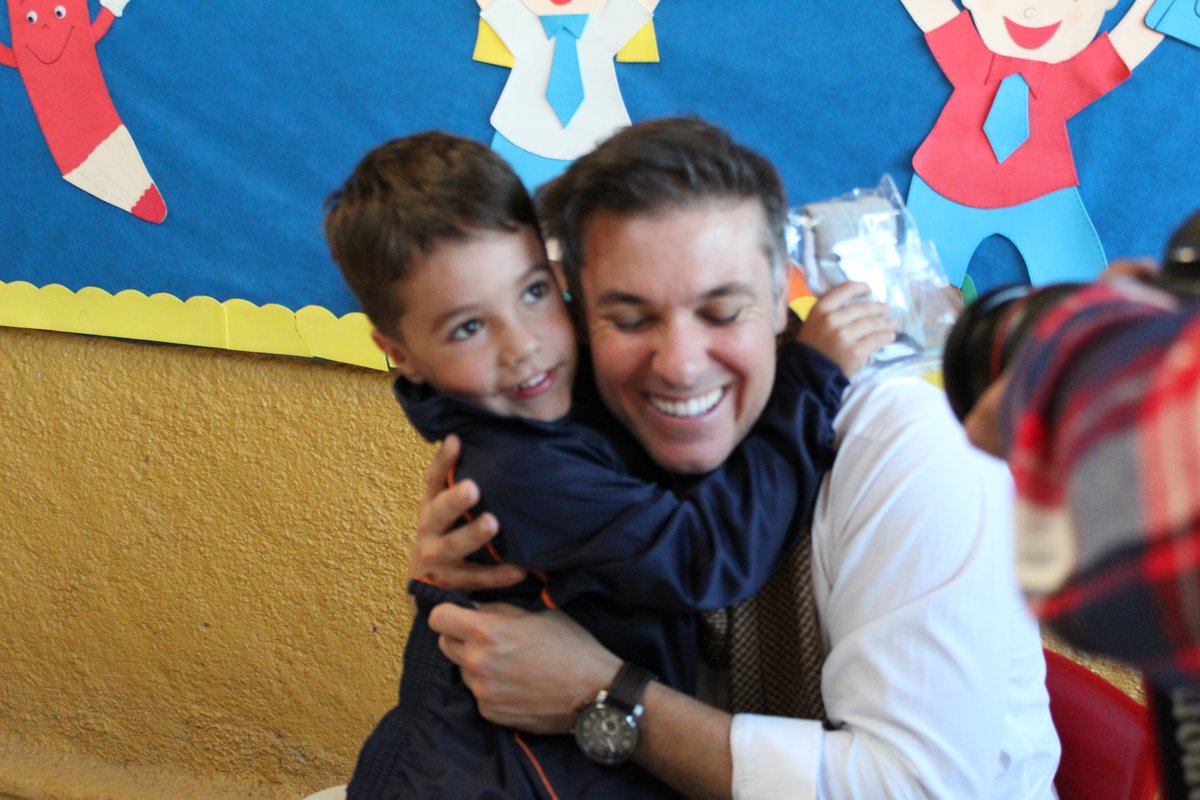 Divaldo Lara abraça aluno da Educação Infantil durante entrega do novo uniforme escolar.