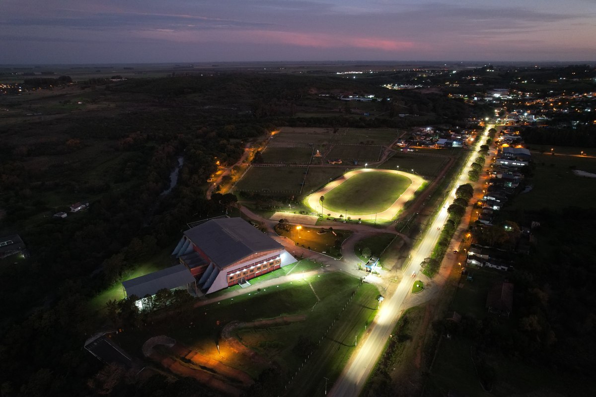 Vista aérea noturna da pista de atletismo do Militão iluminada.