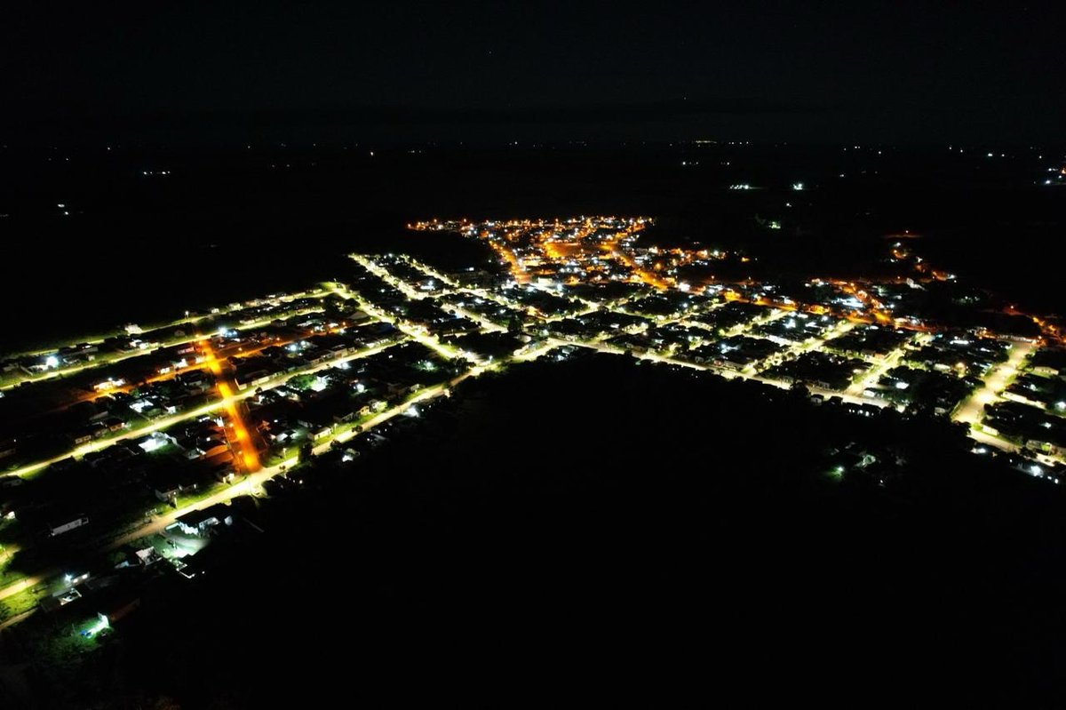 Vista aérea noturna de bairro de Bagé com iluminação pública em LED.