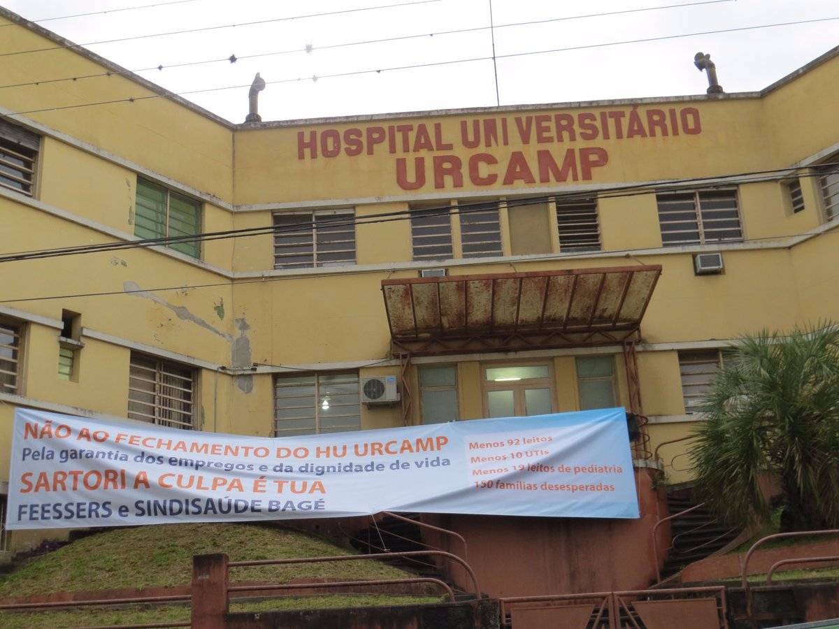 Fachada do Hospital Universitário URCAMP com faixa de protesto contra o fechamento.