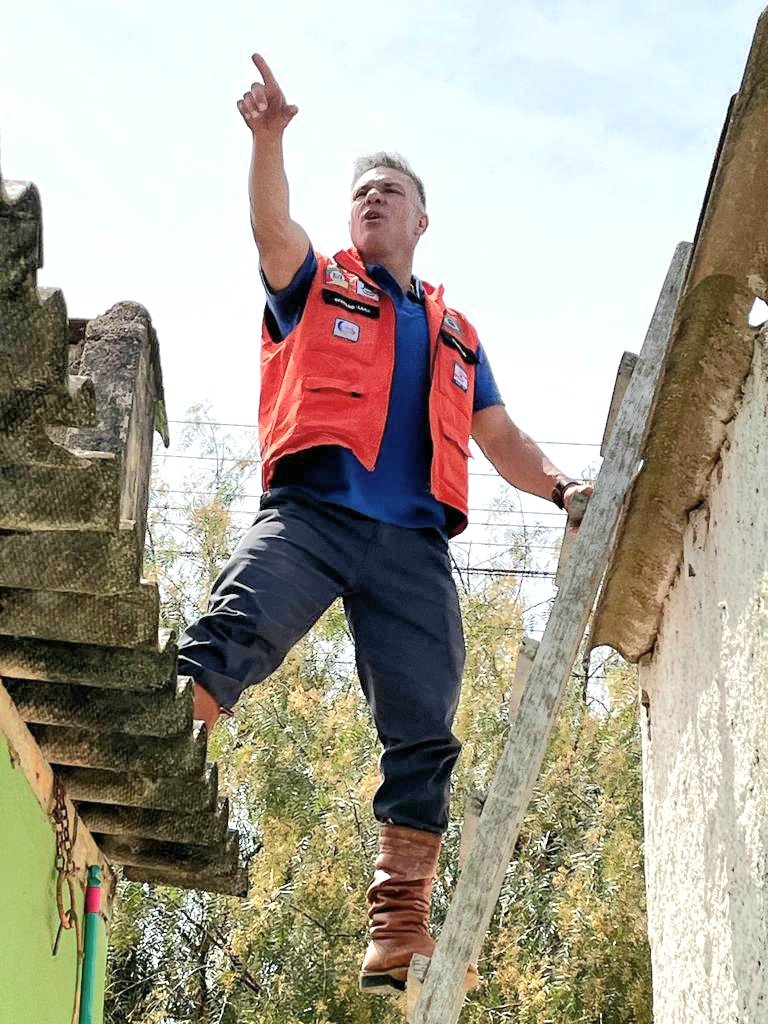 Divaldo Lara em telhado durante ação de socorro após o temporal de granizo em Bagé