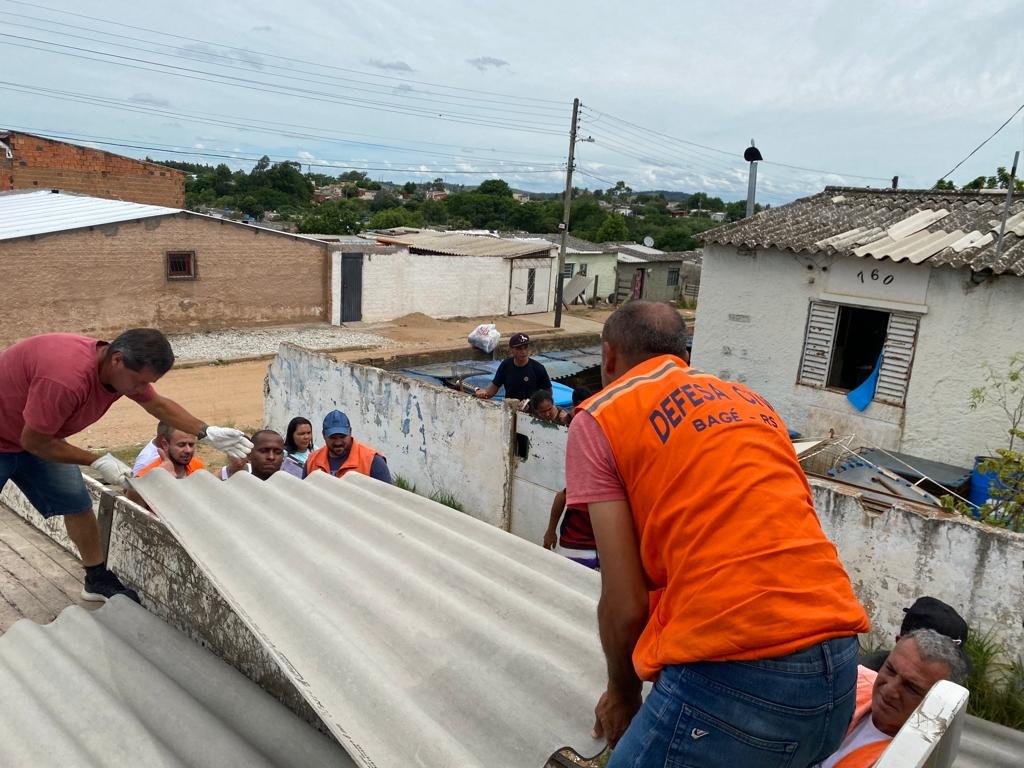 Voluntários e equipes da Defesa Civil ajudam na reconstrução de telhados em Bagé.