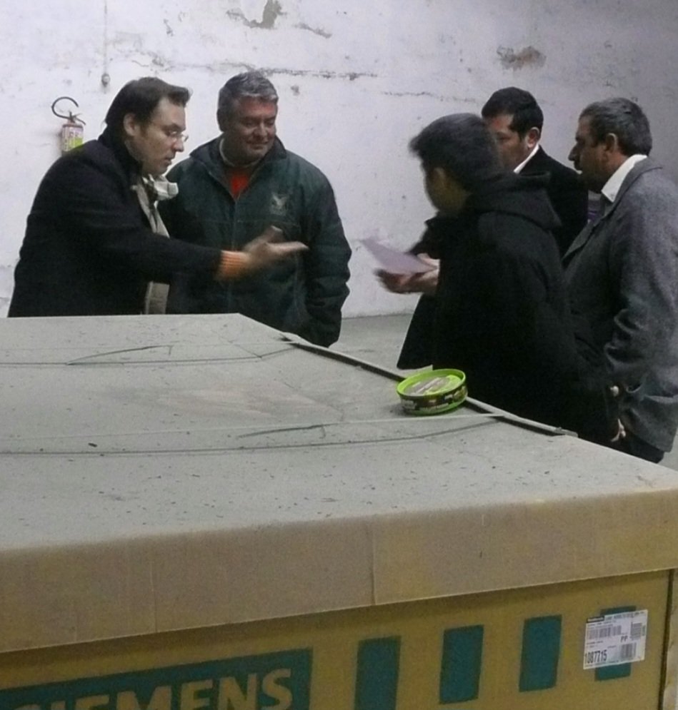 Equipe do Governo Municipal inspeciona a caixa do tomógrafo Siemens antes da instalação.